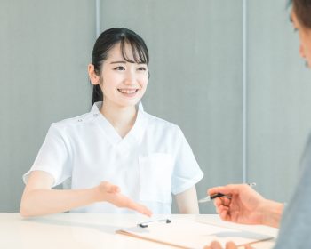 看護師と問診表を記入する男性